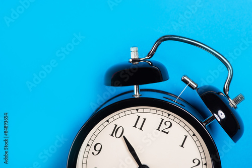 Fotografie, Obraz Old vintage alarm clock standing on the blue surface