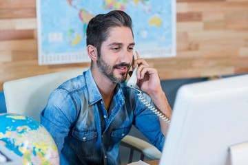 Smiling travel agent having phone call