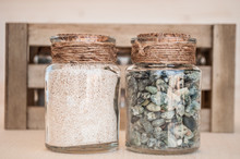 Small Glass Jars With Sand And Stones From The Beach