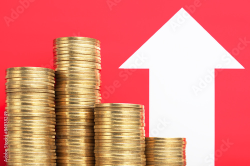 Fotografia, Obraz Pile of coins and growing arrow. More money. Increase income.