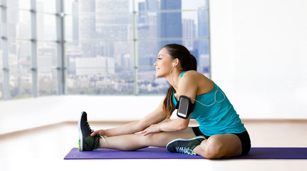 Sticker - smiling woman stretching leg on mat over gym