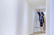 © highwaystarz - Female Electrician Installing Lights In Ceiling