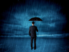 Business Man Standing In Rain With An Umbrella