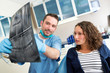 © Production Perig - Young attractive dentist showing x-ray to patient