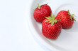 Red strawberries on a white dish