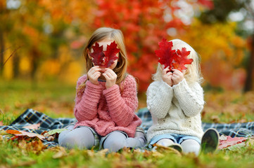  Two sisters having fun together in autumn park