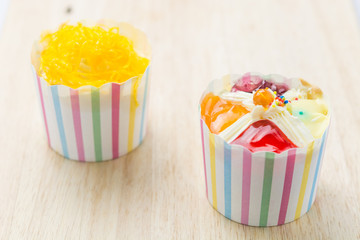 Wall Mural - Two cupcakes on a wooden table.