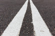 Asphalt road with white double solid line.