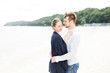 © ilya_oreshkov - European couple relaxing on the sea beach hugging each other and talking..