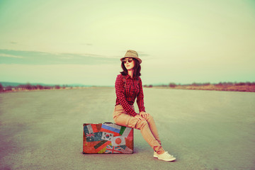 Wall Mural - Traveler sitting on suitcase outdoor