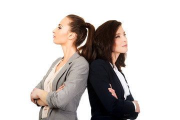 Two businesswoman leaning on each other.