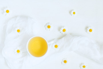 Wall Mural - Teacup of natural chamomile herbal tea on white kitchen table