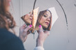 © tinx - Beautiful girl looking at herself in a mirror