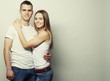 © Raisa Kanareva - lovely happy couple hugging over grey background.