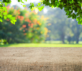 Empty table and sack tablecloth over blur tree background, for product display montage