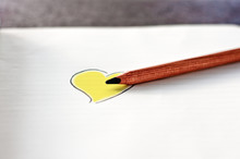 Pencil Lying On A Notepad With A Drawing Of A Yellow Heart
