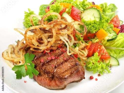 Fototapeta na wymiar Steak mit Salat und Zwiebelringen