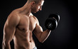 © Zoran Zeremski - Young man with bare chest lifting dumbbells on black background.