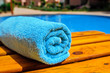 blue rolled-up towel lying on a lounger near the pool
