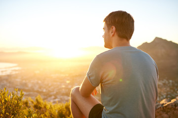 Young guy sitting on a nature trail at sunrise