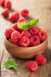 fresh raspberry in bowl over wooden background