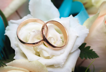 Gold wedding rings on a bouquet of flowers for the bride