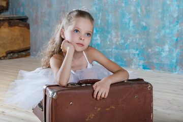 Wall Mural - Little adorable ballerina in white tutu with old vintage suitcas