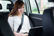 © zhu difeng - Beautiful asian young woman using laptop in car
