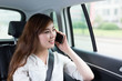 © zhu difeng - Beautiful asian young woman making phone call in car as passenge