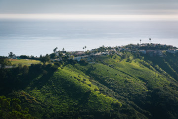 View of green hills and houses overlooking the Pacific Ocean, in