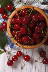 Wall Mural - Tasty cherries in a wooden bowl vertical view above, rustic
