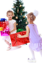 Sticker - Girls sisters around the Christmas tree fuss considering boxes w