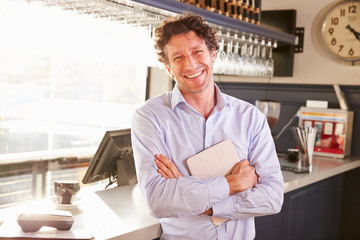 Male restaurant owner holding digital tablet, portrait