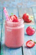 strawberry smoothie in a jar with a straws
