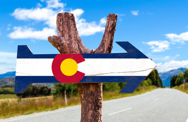 Wall Mural - Colorado Flag wooden sign with road background