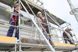 Fototapeta  - Construction workers installing scaffolding on site