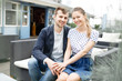 © ilya_oreshkov - A young couple spends time on the couch in the outdoor cafe near the Baltic Sea