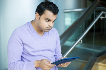 Canvas Print - Man frustrated by what he sees on tablet