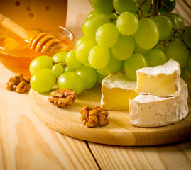 Wall Mural - Still life of cheese, honey, walnuts and grapes