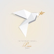 international peace day vector illustration of white origami dove bird with golden olive branch