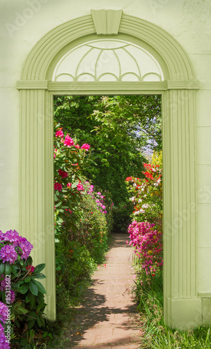 Naklejka na drzwi Torbogen mit Blick auf blühende Rhododendren