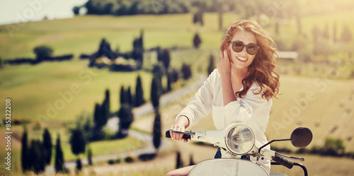 Plakat Portrait of summer girl on scooter - Outdoor on Tuscany hiills.