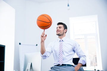 Canvas Print - Happy businessman spining ball in office