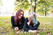 © Westend61 - Two female friends with colored hair lying on a meadow