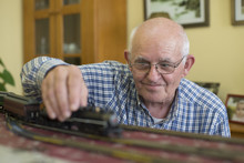 Portrait Of Smiling Senior Man With His Model Railway