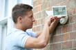 © highwaystarz - Security Consultant Fitting Security Light To House Wall