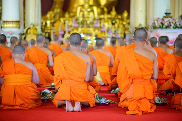 buddhist monks pray to buddha in thai temple
