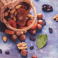 Wall Mural - Healthy concept: assortment of dry fruits and nuts on blue rustic background. Selective focus