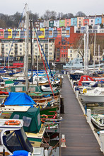 Pleasure Craft Moored In Bristol Harbour, Overlooked By The City's More Colorful Housing 