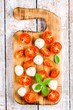 mozzarella, cherry tomatoes and basil on old cutting board